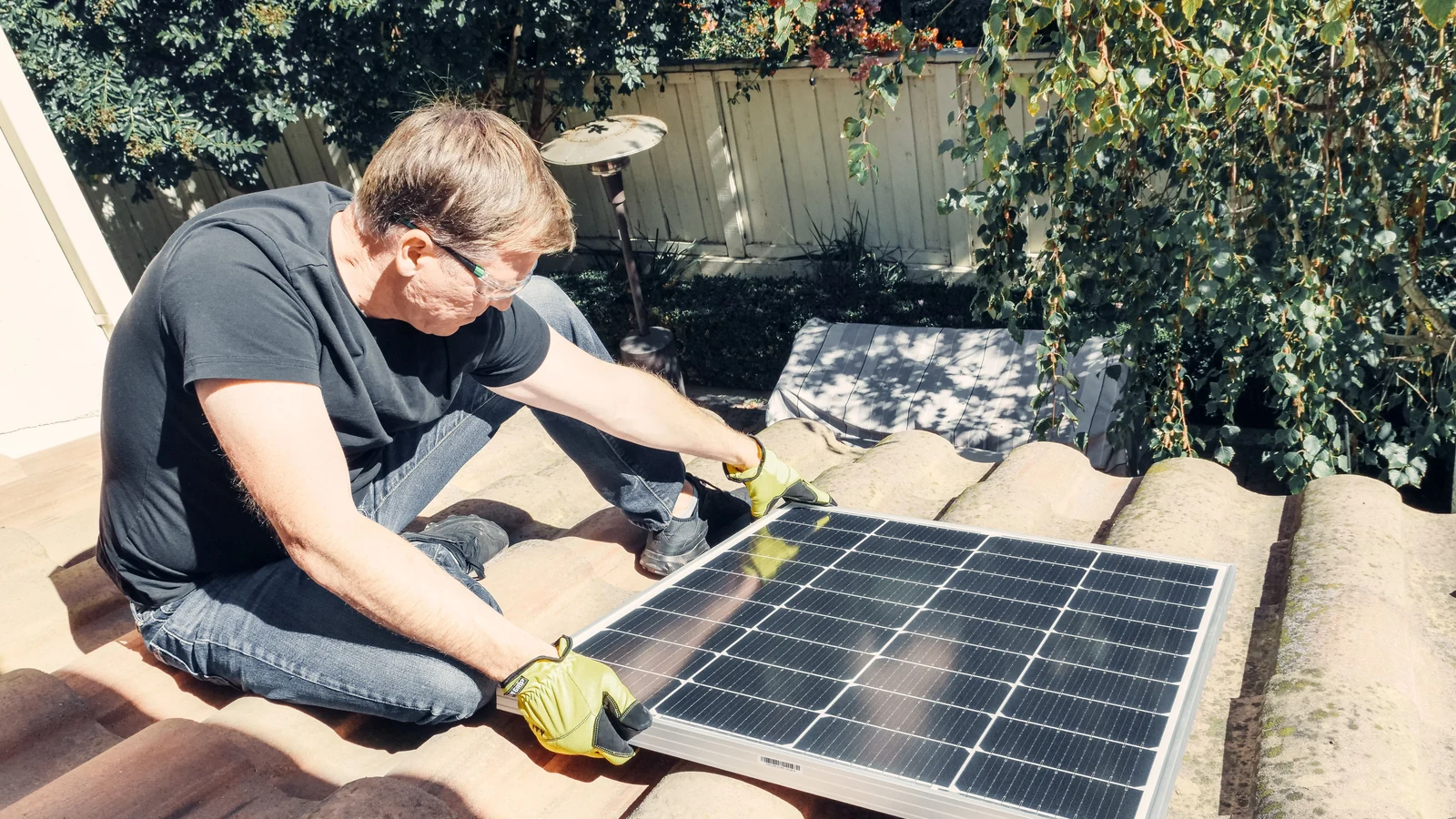 Technicien examinant une toiture et un panneau avant une installation solaire
