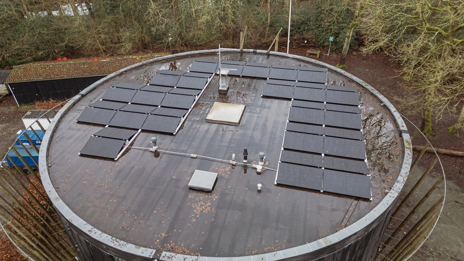 Bâtiment entouré de végétation avec une grande installation solaire en toiture